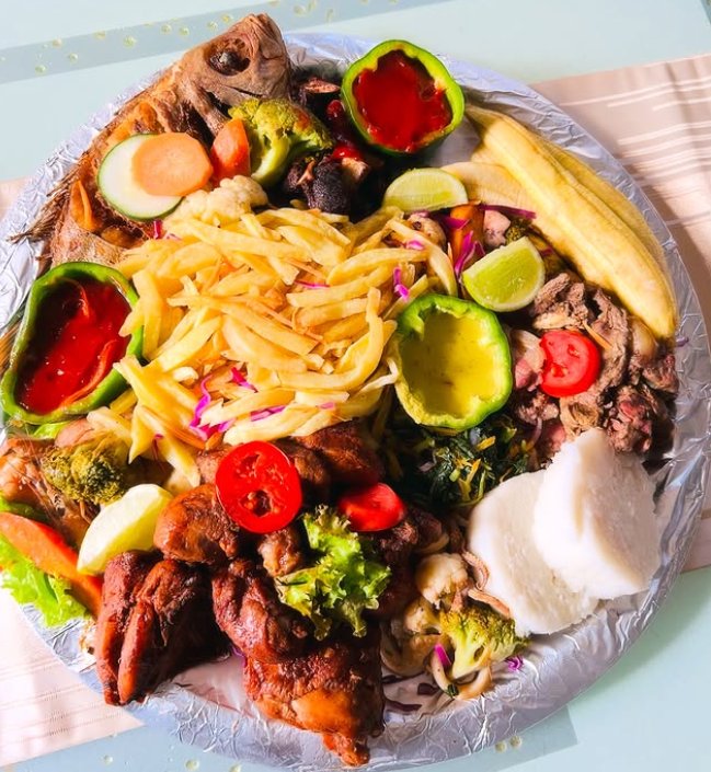 A loaded Ununio sharing platter of grilled fish, chicken, chips, ugali and vegetables